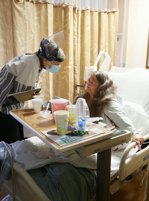 APPLE VALLEY, CALIFORNIA: Sister Terry Maher, a chaplain, provides spiritual care for a patient in a non-COVID zone at Providence St. Mary Medical Center on February 4, 2021 in Apple Valley, California. (Photo by Mario Tama/Getty Images)
