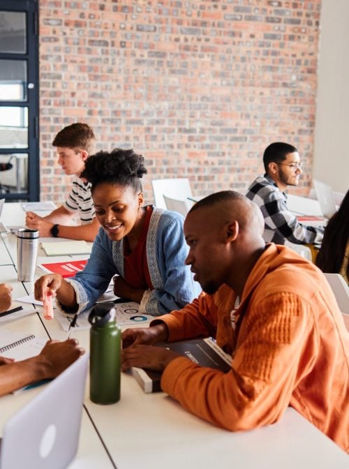 Group of students studying together while sitting around a table at school. (Goodboy Picture Company/Getty Images)