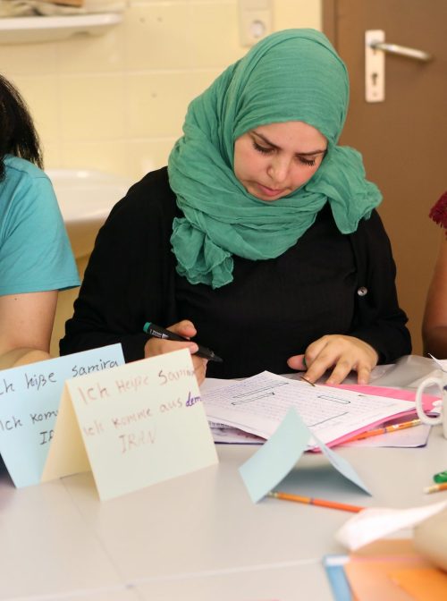 BERLIN, GERMANY - AUGUST 06: (L-R) Refugees Samira from Iran, Fatima from Palestine and Mebrhit from Eritrea, with her son Esey, attend a German language class at a temporary home providing assistance for refugees on August 6, 2015 in the Gatow district of Berlin, Germany. Since the beginning of the year, around 300,000 refugees, most recentlypredominantly from Iraq, Syria, and Afghanistan, have registered as asylum seekers in the country, a figure with which the country has been struggling to cope, particularly on state levels. (Photo by Adam Berry/Getty Images)