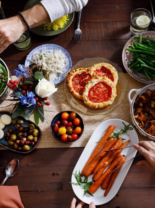 Hands serving food at an interfaith potluck. (Kelly Feldmiller)