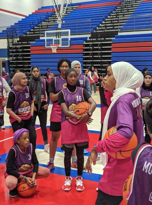 Bilqis Abdul-Qaadir, right, talks to players during a Hooping In Faith basketball program in July 2023. Photo by Amna Masoud