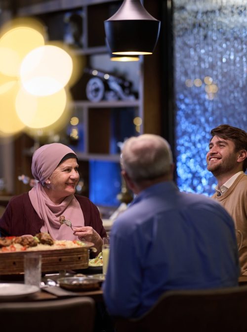 A modern and traditional Islamic family comes together for iftar in a contemporary restaurant during the Ramadan fasting period, embodying cultural harmony and familial unity