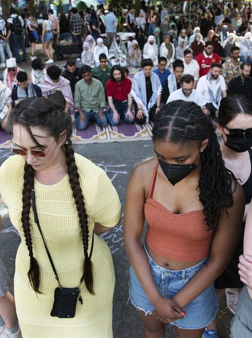 Students form a protective wall as Muslims pray with students protesting the Israel-Hamas war at George Washington University in Washington, Sunday, April 28, 2024. (AP Photo/Cliff Owen)